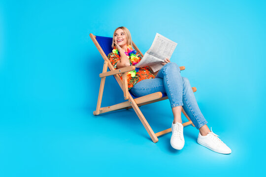 Photo of positive adorable girl wear trendy print clothes weekend tour look empty space isolated on blue color background