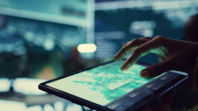 Navy operations specialist examines a world map with gps system on his tablet, working on finding tracks of enemy vessels. General employs government satellite data for missions. Close up. Camera B.