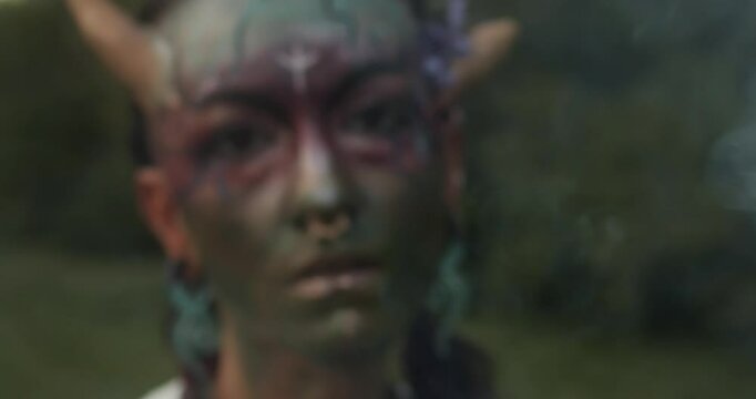 This video captures the spirit of the Celtic fire festival with a focus on a woman adorned with beautiful face paint, dancing in the warm glow of the bonfire.