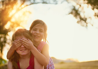 Children, happy and piggyback with cover eyes or sunshine in backyard playing, games and outdoor. Kids, siblings and together in nature for summer bonding activity for happiness, youth and friends