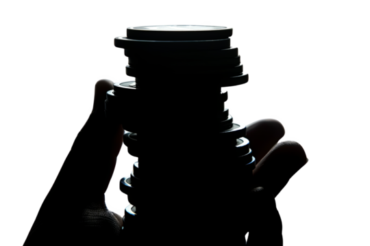 Silhouette of a hand holding a stack of coins against a black background, emphasizing financial savings and investment concepts. - Powered by Adobe