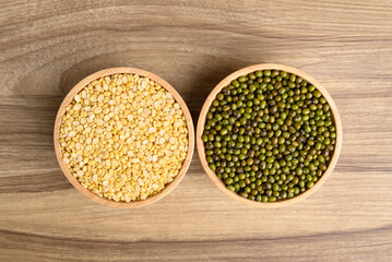 Yellow peeled split mung bean and green mung bean seed in bowl on wooden background, Food...