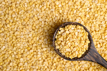 Yellow peeled split mung bean in spoon for food background, Food ingredient, Top view