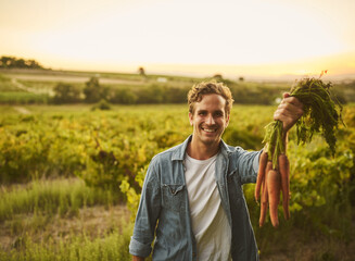 Nature, smile and portrait of man with carrots on farm for agriculture, sustainable and harvest...