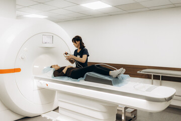Radiologist with a female patient in the room of computed tomography