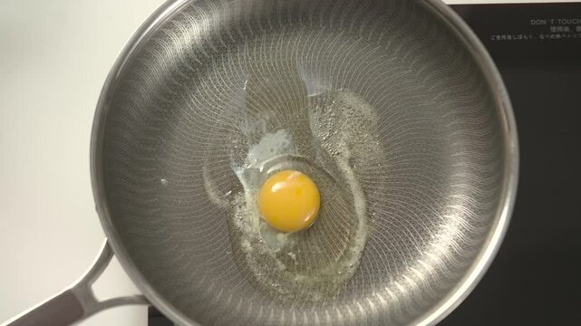 Watch a perfect sunny-side-up egg sizzle with a runny yolk and crispy edges.