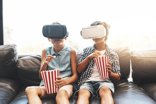 Siblings, popcorn and virtual reality headset in home of cyber experience, metaverse system or gaming connection. .Girl, boy and VR movie in living room for future, innovation and ui video technology