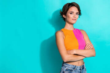 Photo of pretty adorable woman wear pink orange top arms folded empty space isolated teal color...