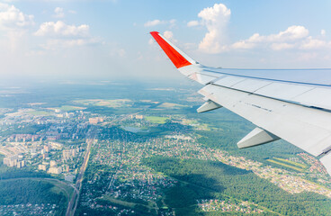 Fototapeta premium View from the airplane window during taking off on a clear summer morning