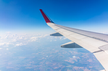 Obraz premium View from the airplane window at a beautiful cloudy sky and the airplane wing