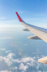 Obraz premium View from the airplane window at a beautiful cloudy sky and the airplane wing