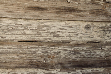 Fototapeta premium Close-up of weathered wooden boards with peeling paint, showcasing natural textures and grain patterns. The wood appears aged and rustic, with visible knots and cracks.