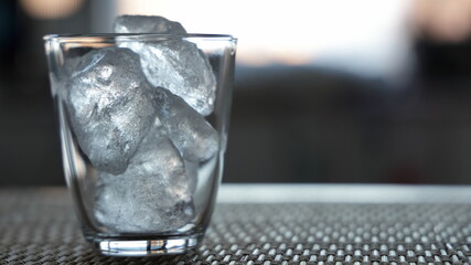 A transparent glass filled with ice passed through the light