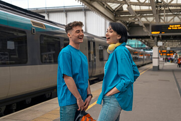 Young happy smiling couple waiting for train
