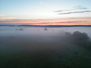 Obraz premium Sonnenaufgang über Schweinfurt mit Nebelschleiern, Nebel über den Feldern, mit einem Bach und Bäumen und die aufgehende Sonne am Horizont, Drohnenfoto, Luftaufnahme, Schweinfurt, Bayern, Deutschland