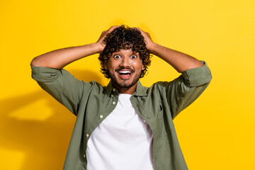 Portrait photo of young latin guy in khaki shirt surprised black friday sale low prices isolated on yellow color background