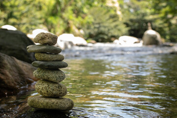 Serene Stack of Rocks Amidst Tranquil Colombian River Flow