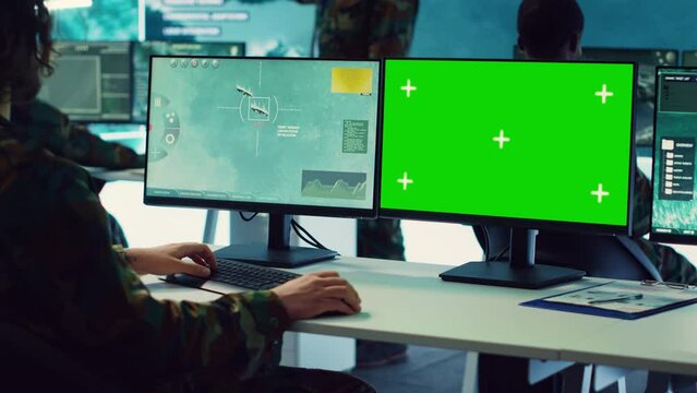 Army officer uses satellite radar footage and a greenscreen in military command post, working to gather intelligence and detect enemy ships. Commander operator at government agency. Camera A.