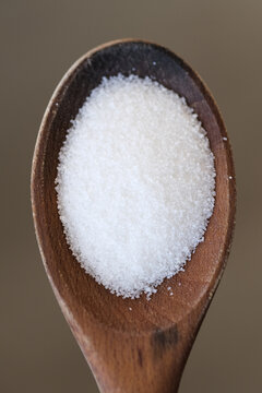 Sugar grains on a wooden spoon
