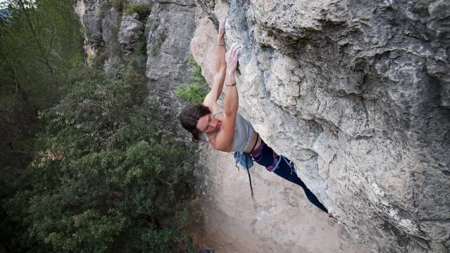  Strong female climber reaching the top of a hard route in Calders, Catalonia, Spain. High quality 4k footage.