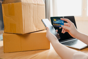 close up phone and credit card in online seller woman's hand with box background