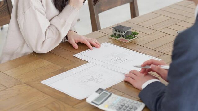 不動産の営業を受ける女性の手元