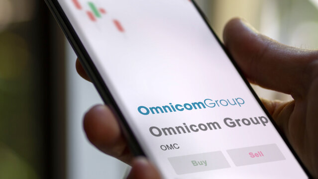 April 09th 2024 , New York City, New York. Close up on logo of Omnicom Group on the screen of an exchange. Omnicom Group price stocks, $OMC on a device.