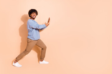 Full size photo of serious middle eastern guy dressed blue pullover trousers pushing empty space isolated on pastel color background