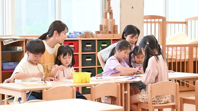 学童や放課後デイサービス等で勉強をする先生と生徒　小学生複数の動画の広角