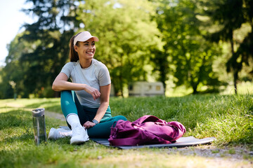 Happy athletic woman relaxing after exercising in  park.