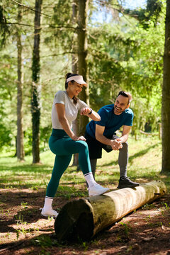 Happy athletic woman checking the time on wristwatch while exercising with her friend in park. Copy space.