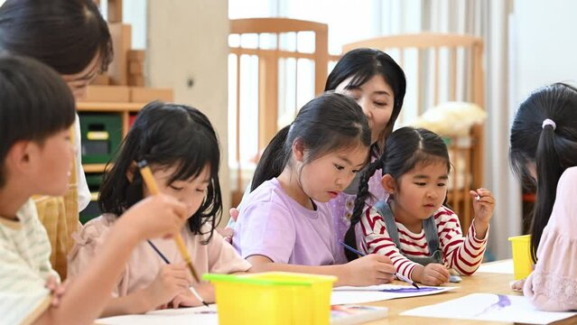 学童や放課後デイサービス等で勉強をする先生と生徒　小学生複数の動画
