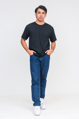 Fototapeta premium Casual asian man in black shirt and jeans standing confidently