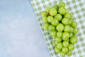 The Fresh of Shine Muscat Grape with tablecloth on wooden blue background with copy space.