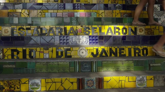 Tourists walk in colorful ceramics stair in Rio de Janeiro. Selaron Escadaria pottery artwork detail