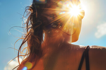  close up of sunburn on woman's back, blue sky with bright sunshine in background