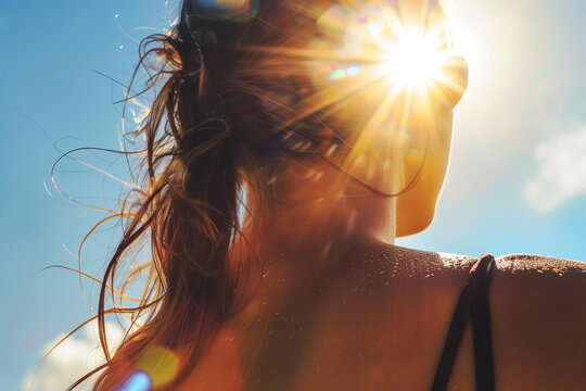 
close up of sunburn on woman's back, blue sky with bright sunshine in background