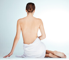 Woman, back and beauty in naked studio, wellness and selfcare or towel on white background. Female...
