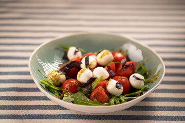 Fresh flavorful salad with mozzarella, cherry tomatoes and basil leaves