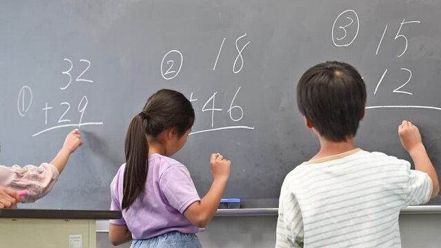 黒板で算数を勉強する小学生複数　顔無しの後ろ姿の動画