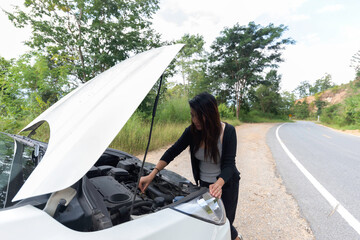 Asian tourist Young woman is calling to car mechanic to repair broken car.