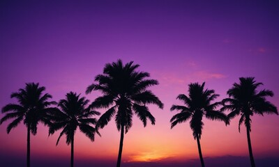 Silhouettes of palm trees against a purple sunset