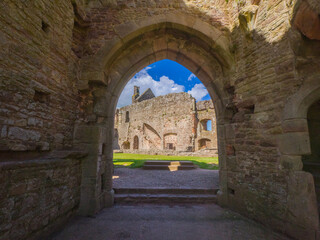 Fototapeta premium Looking at chapel remnants in the courtyard through an archway of Raglan Castle (Wales, United Kingdom)
