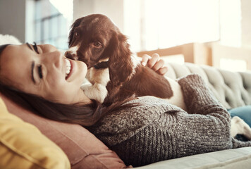 Happy, relaxing and woman with dog on sofa bonding with pet in living room at apartment. Smile,...
