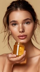 Fototapeta premium Beautiful smiling young woman with clean skin holding facial essential oil or serum with dropper, rejuvenation and skin care, white background