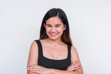 A portrait of a simple, young Asian woman with prominent ears in a black top, smiling, isolated on a white background