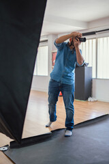 Photographer shooting a model in a studio with a softbox