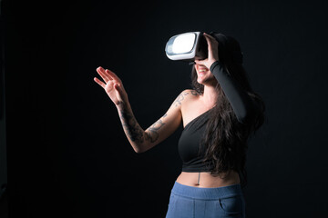 Woman wearing virtual reality headset against dark background