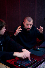 in the recording room dark With neon-lit studio, a sound recorder teaches his junior assistant how...