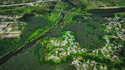 aerial top view village rural country side outskirts landmark environment with private cottages near trees and river natural space in bright summer day time